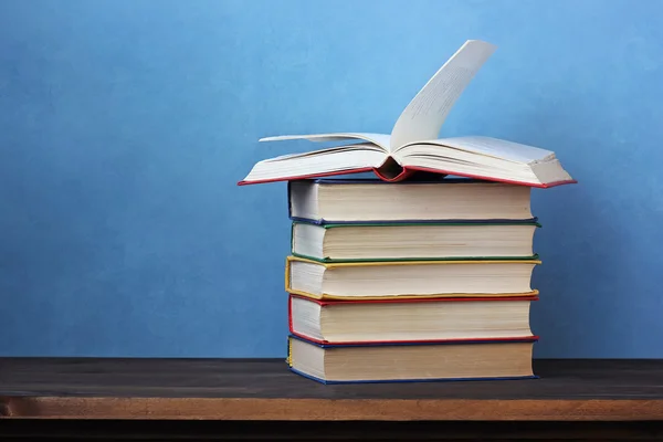 Pilha de livros em uma mesa de madeira . — Fotografia de Stock