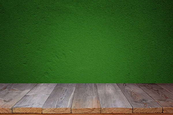 Mesa de madeira contra uma parede verde — Fotografia de Stock