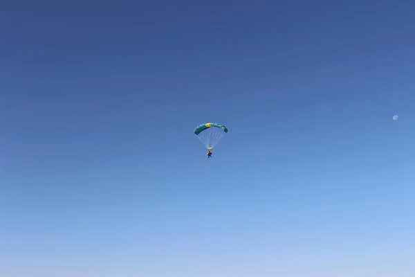 Person falling from the sky by parachute