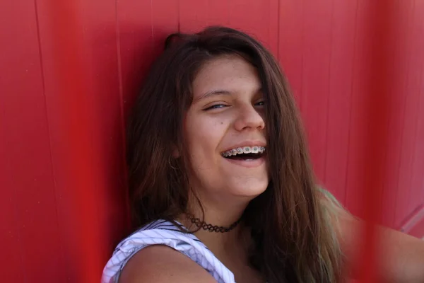 Teenage Dívka Rovnátka Opírající Červenou Zeď Smích — Stock fotografie