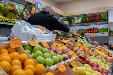 Meyve satıcısı müşterilerine servis yapıyor.