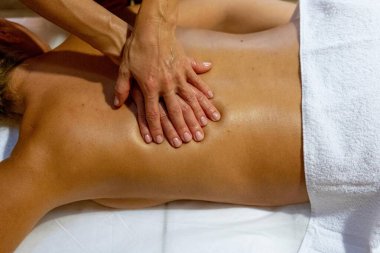 Masaj terapisti bir müşteriye sırt masajı yapıyor.