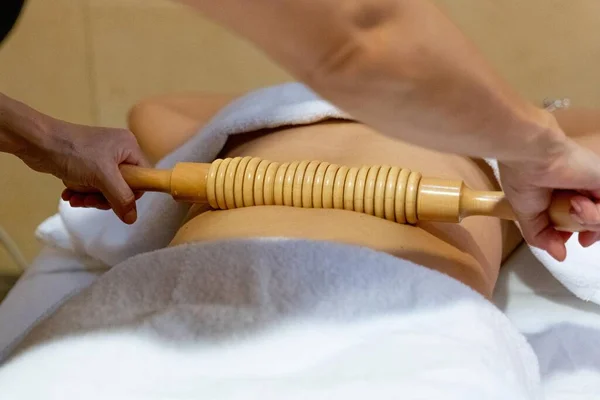 Masseuse giving a wood massage therapy massage to a client