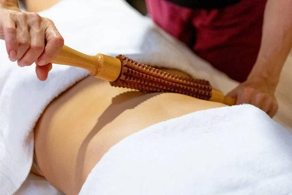 Masseuse giving a wood massage therapy massage to a client