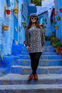 Fas 'ta Chaouen' in mavi sokaklarında poz veren genç kız.