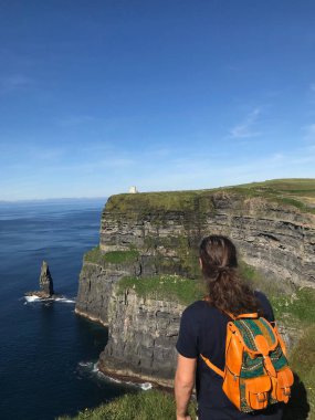 İrlanda 'daki Moher Kayalıklarına bakan genç adam
