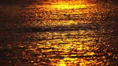 Gün batımı renkli gökyüzüne karşı denizi yansıtır