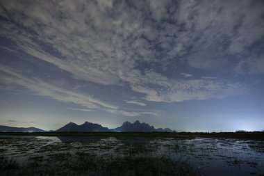 Gece vakti bulutlu gökyüzünde bir yıldız.