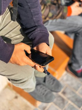 Telefonunu karıştıran tanınmayan bir insanın elleri duvara yaslanmış.