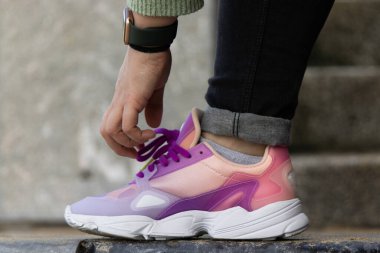 Ayakkabı bağcıklarını bağlayan kişinin yakın plan fotoğrafı.