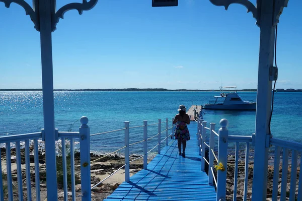 在古巴皮拉尔海滩 身穿五颜六色衣服的女人穿过蓝色的码头 — 图库照片