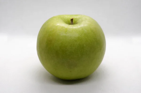 一个绿色苹果的近景 在白色背景的软盒里拍的 — 图库照片
