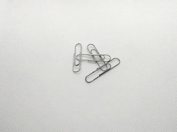 A bunch of paperclips over a white floor
