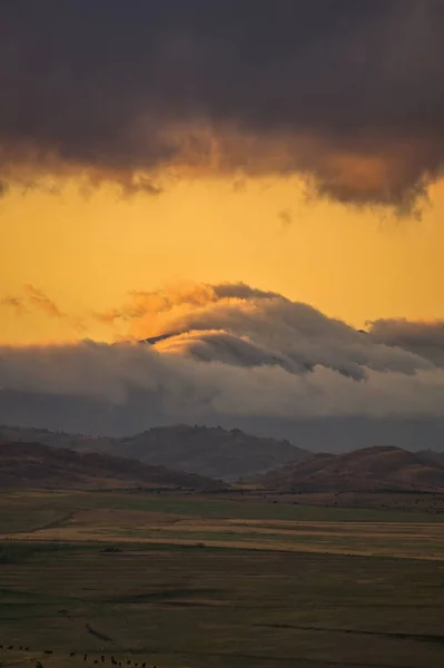 Alçak bulutlar gün batımında Sierra de la ventana 'da dağlarla karışıyor.