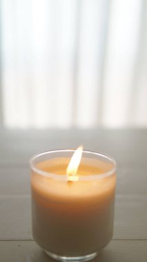 Aydınlatılmış beyaz ve gri arkaplanı olan mum yakın görünümü