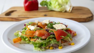 Beyaz bir masanın üstünde taze ve lezzetli bir salata.