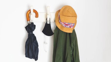  Eğer yeni normalin dışına çıkıyorsan ihtiyacın olan şeyler CV19 yüzünden. Palto askısına, şemsiyeye, paltoya, yüz maskelerine ve kulaklıklara asılıydı. Beyaz bir duvarın üstünde