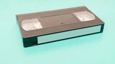 Cyan yüzeyi üzerinde boş etiket olan eski bir VHS kasetinin yakın görüntüsü