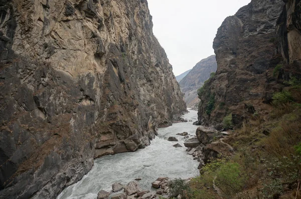 Dağ nehrinin üzerindeki dev uçurumlar. Dikey kahverengi kaya oluşumları.