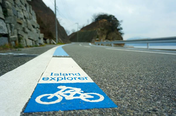 Japonya 'da boş bir otoyolda mavi ve beyaz bir motosiklet yolu tabelası