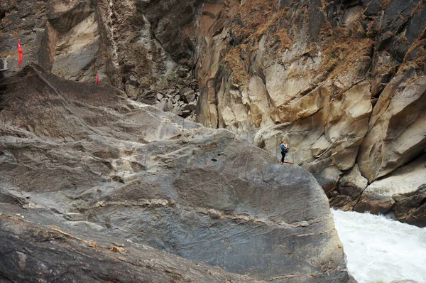 Uçurumun kenarında duran yalnız Avrupalı kız. Dev kahverengi kaya oluşumu. 
