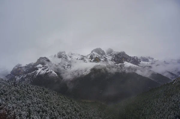 Kar yağarken görkemli karlı dağ sıraları     