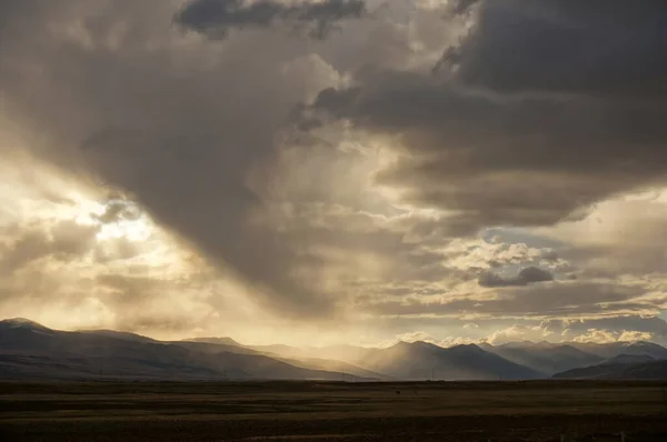 Altın yağmurlu bulutlar günbatımına karşı