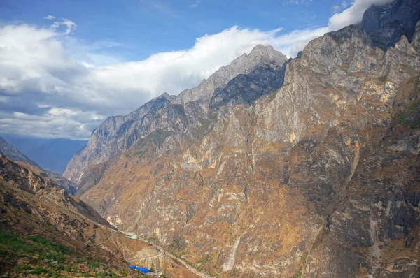 Dağın tepesinden manzara. Bulutlu gökyüzünün altında kahverengi kaya oluşumu 