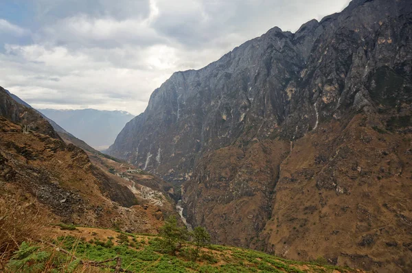 Çin 'deki dağların manzarası. Kahverengi kayalar gri gökyüzünün altında    