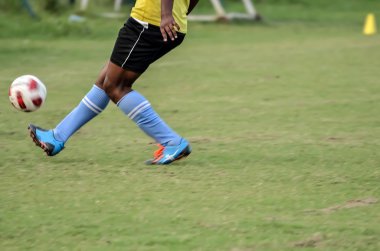 Çocuk futbol oynuyor.