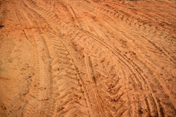 Tire tracks print on dirty red soil. Wheel marks of truck on soil texture background