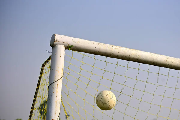 Scoring a goal, close-up of soccer ball tend to enter soccer goal against blue sky