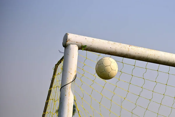 Scoring a goal, close-up of soccer ball tend to enter soccer goal against blue sky
