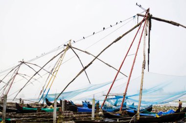 Kerala 'daki Kochi sahilinde Çin balık ağları. Hint Okyanusu 'ndaki sulardan balık yakalayan yerli Hintli balıkçı.