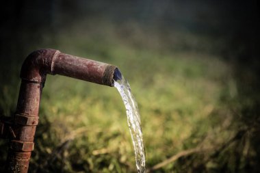 Su israfı. Çelik bir borudan taze su akıyor..