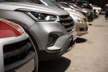 Şehir otoparkındaki yolun kenarına park etmiş arabaların ön görüntüsü.