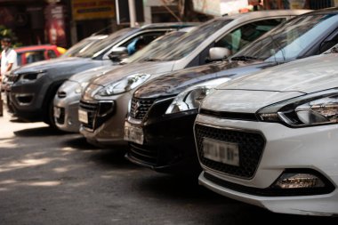 Şehir otoparkındaki yolun kenarına park etmiş arabaların ön görüntüsü.