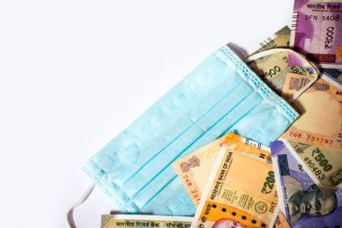 Indian rupee and protective face masks isolated on white background.