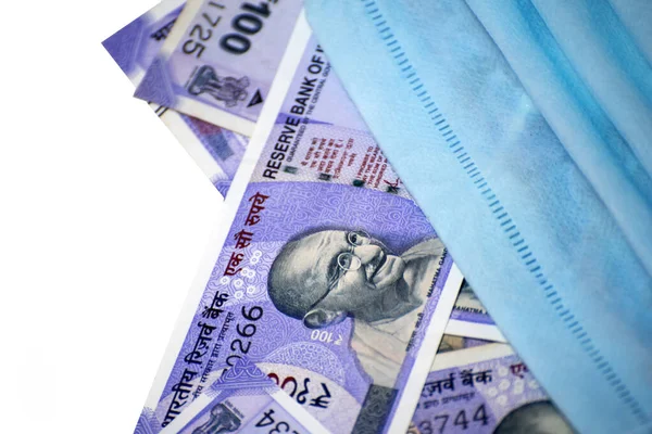 Hindistan 100 rupisi ve yüz maskesi beyaz arka planda izole edilmiş.