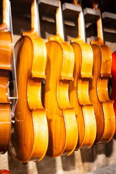 Many violins are hanging in a musical shop for ready to sell