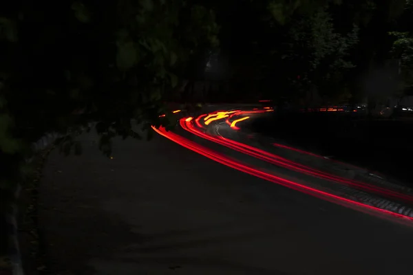暗い黒の夜に街の通りに車のライトトレイル 写真は長時間露光で撮影されます — ストック写真