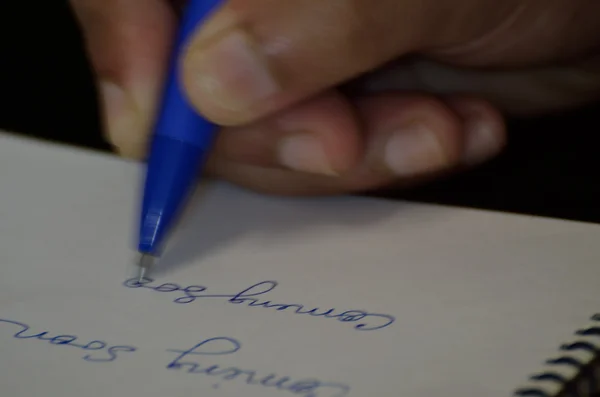 Escritura de mano humana en un bloc de notas — Foto de Stock