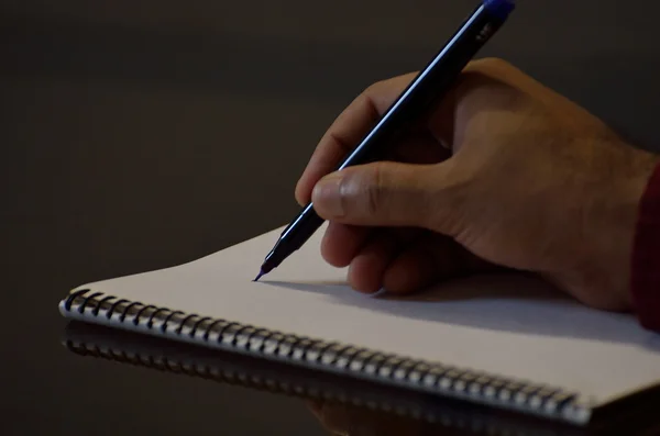 Escritura de mano humana en un bloc de notas — Foto de Stock