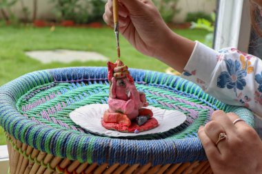 Renkli Lord Ganesha Murti 'yi boyuyorum. Modern kilden ev yapımı heykel.