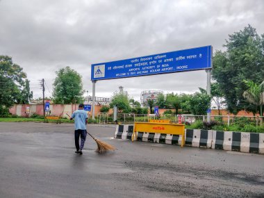 Indore, India - August 22nd 2020: Municipality Worker cleaning road outside Indore Airport. Cleanest city in India 2020. clipart