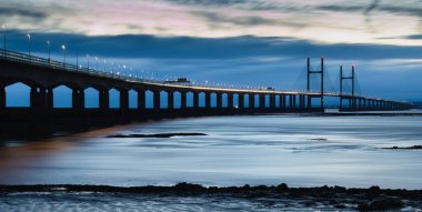 Severn 'den ikinci geçiş. Wales Köprüsü Prensi deniz duvarından gün batımından sonra görüntü