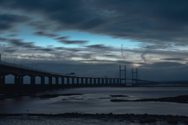 Severn 'den ikinci geçiş. Wales Köprüsü Prensi deniz duvarından gün batımından sonra görüntü