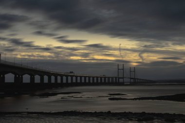 Severn 'den ikinci geçiş. Wales Köprüsü Prensi deniz duvarından gün batımından sonra görüntü