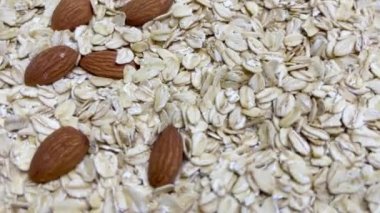 Pişmemiş yulaf ezmesi dokuyu ve bademi kapatır. Makro çekim Döndürmesi