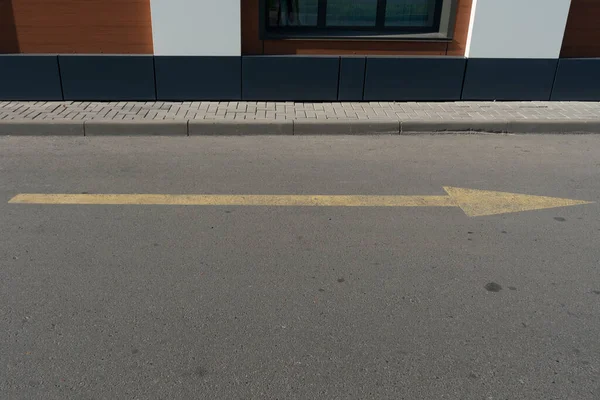 Yellow arrow on the asphalt indicating traffic. — Stock Photo, Image